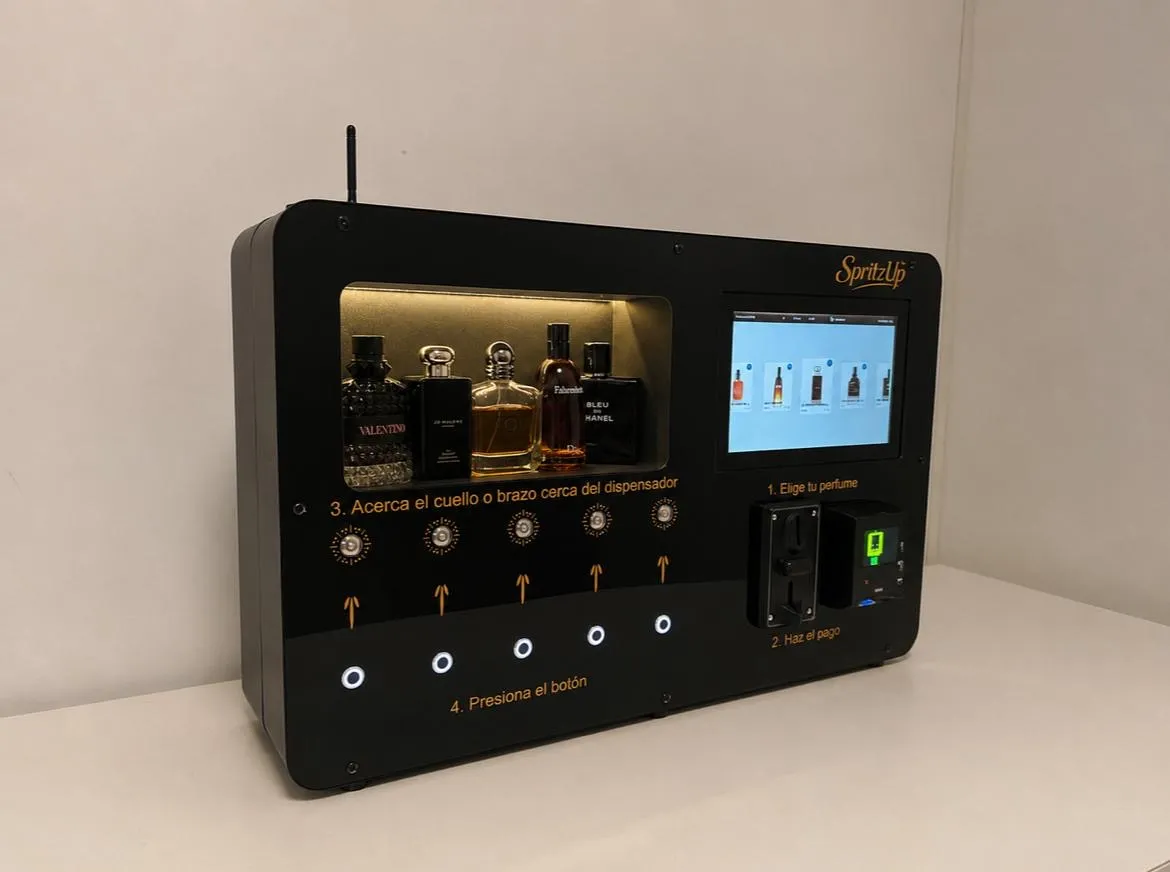 The SpritzUp machine — a three-quarter view of its perfume display, touchscreen, and payment terminal